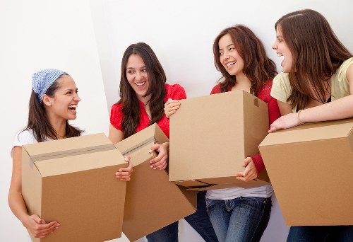 Professional moving team handling packed boxes in Brent