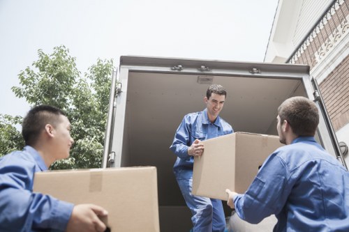 Professional movers loading household items into a van in Brent